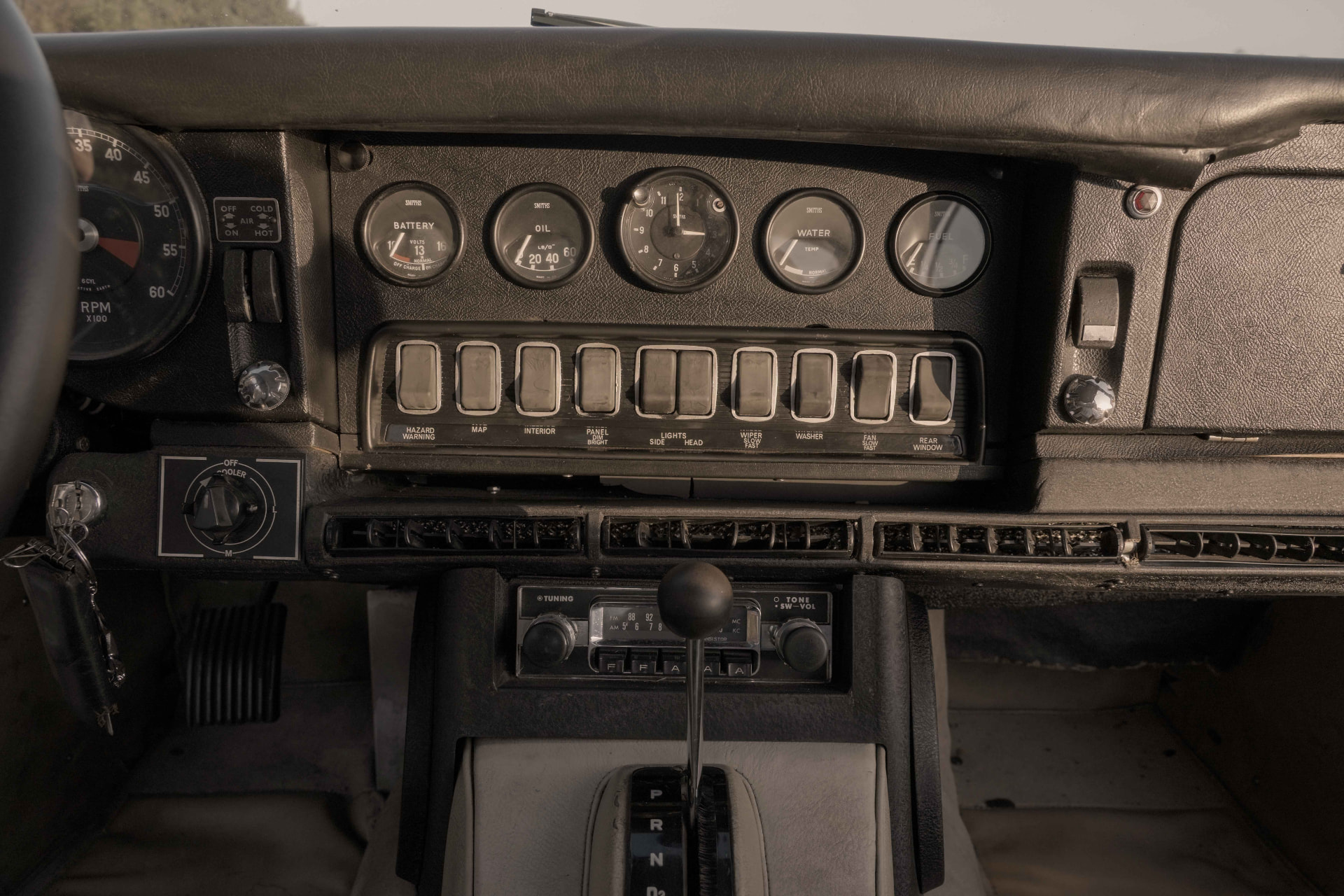 Row of toggle switches and Smiths gauges on the dashboard of a 1968 Jaguar E-Type